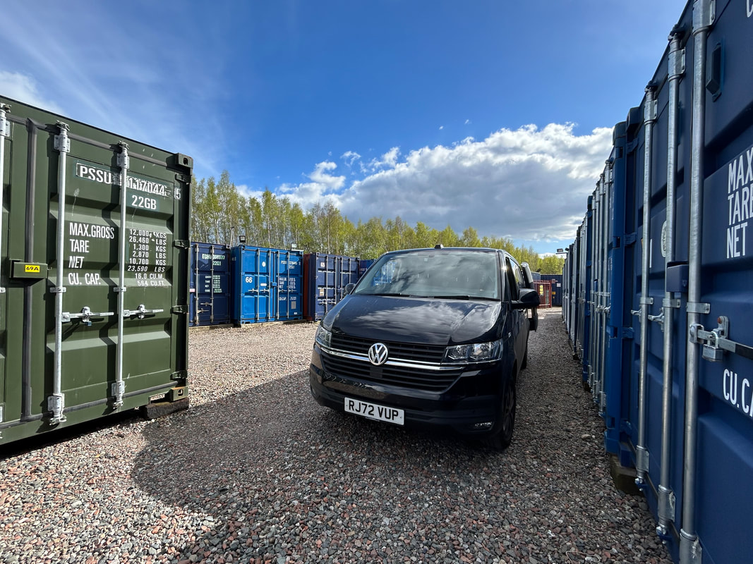 container storage facility showing row of storage units with a van unloading