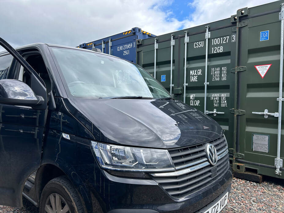 a van unloading goods into a shipping container