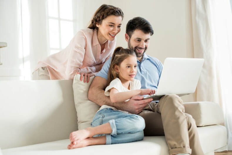 happy family all sat down on a large sofa together with a view of shipping containers