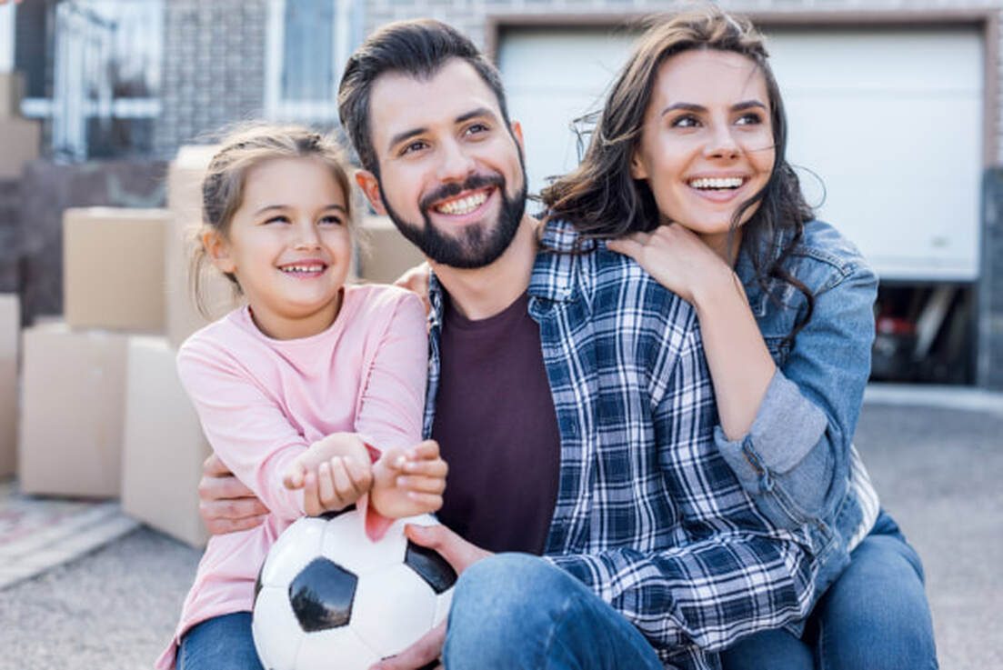 smiling family moving into their new home
