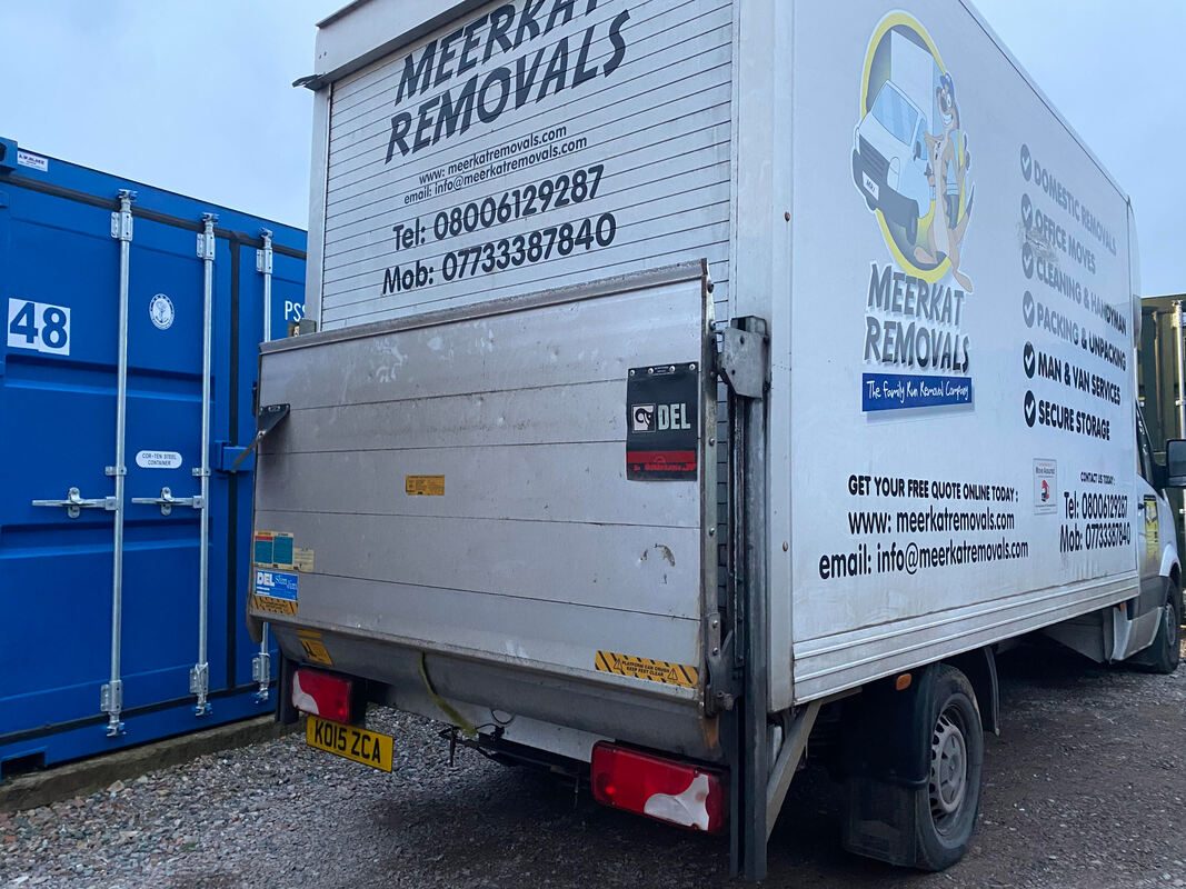 A Luton type removals van unloading on a storage depot