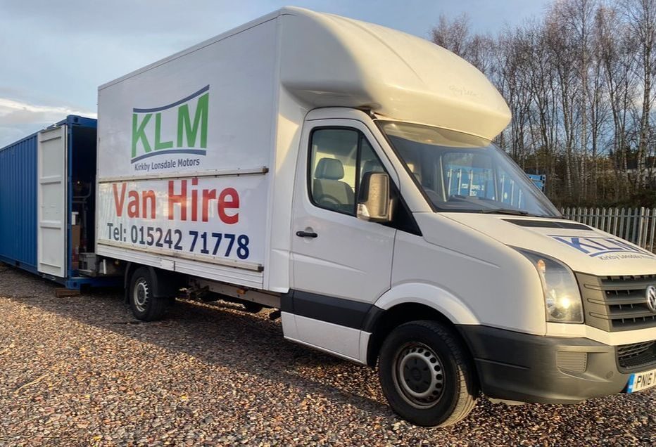 A removal van unloading at a self storage shipping container