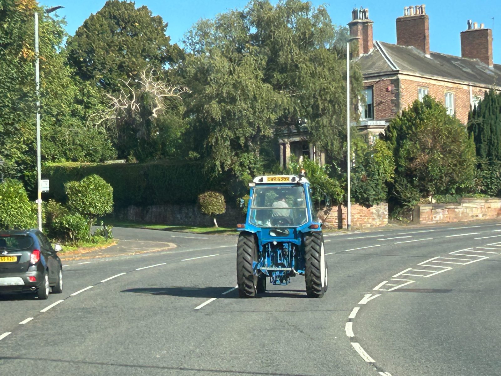 a blue tractor driving on a Cumbrian road