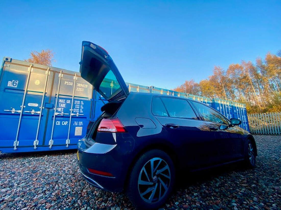 vehicle with boot open about to load contents from a storage container