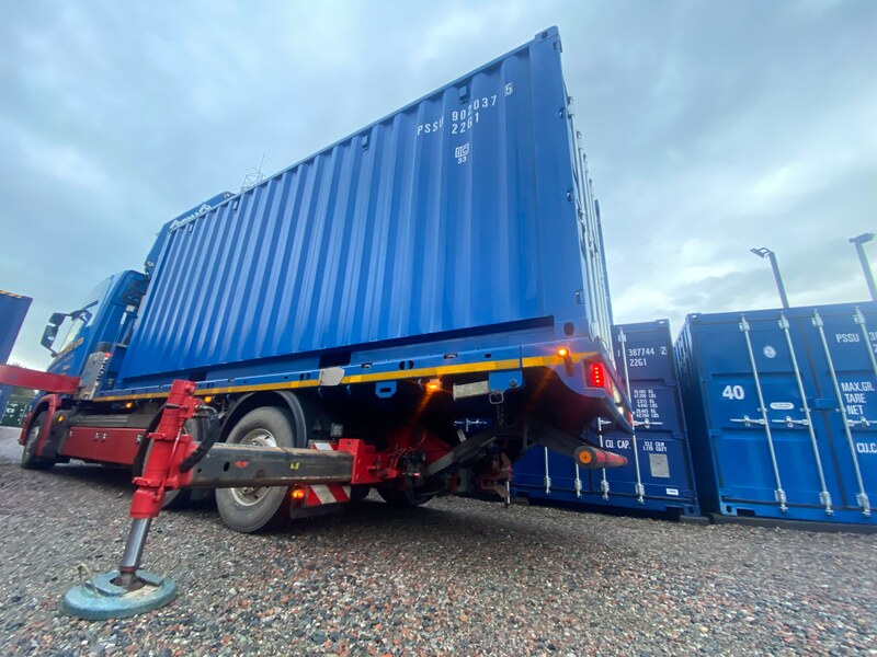 a HIAB delivering a shipping container onto a depot