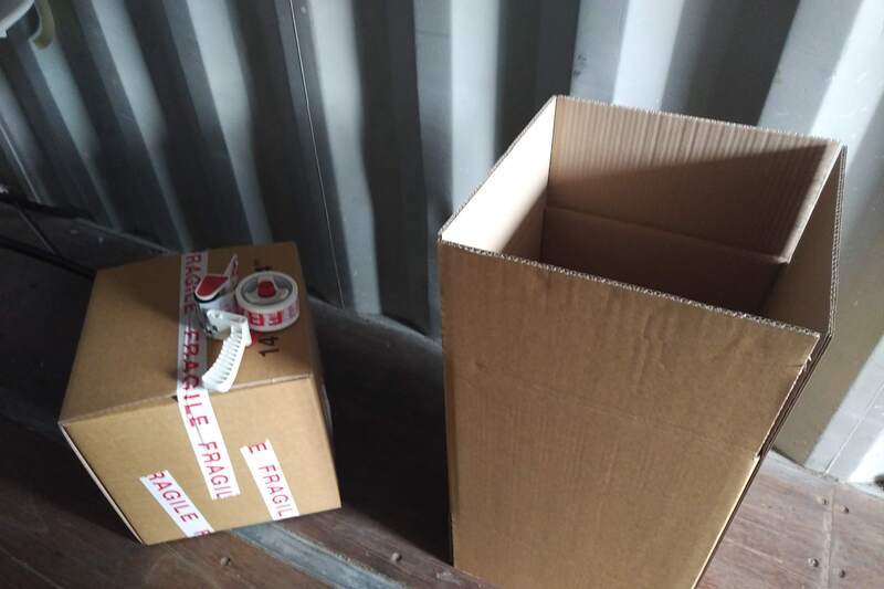 two cardboard packing boxes inside a shipping container